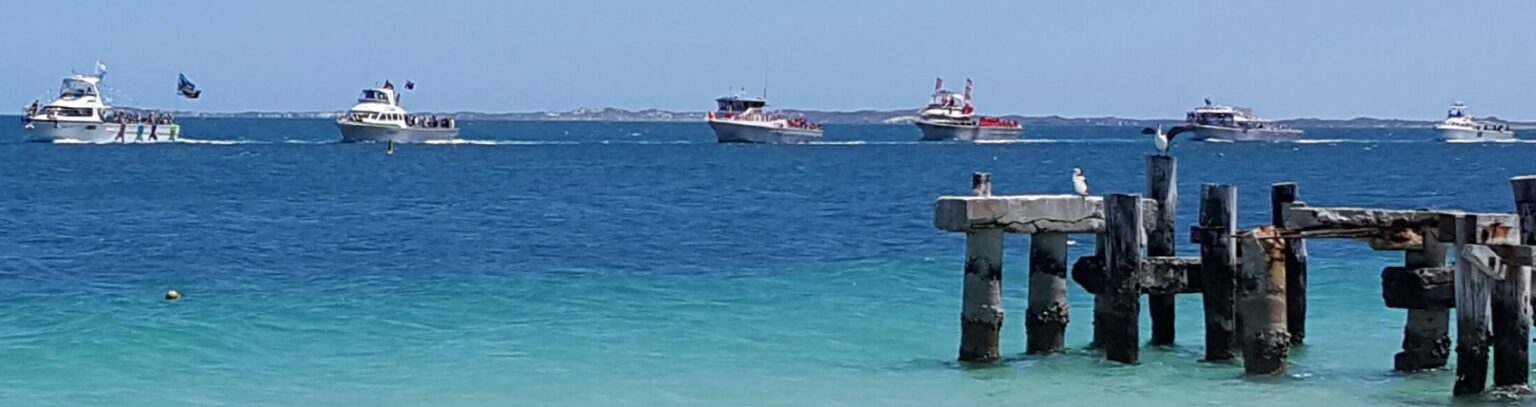 Boats in a procession passing the old jetty in Jurien for the Blessing of the Fleet at Turquoise Coast Festival