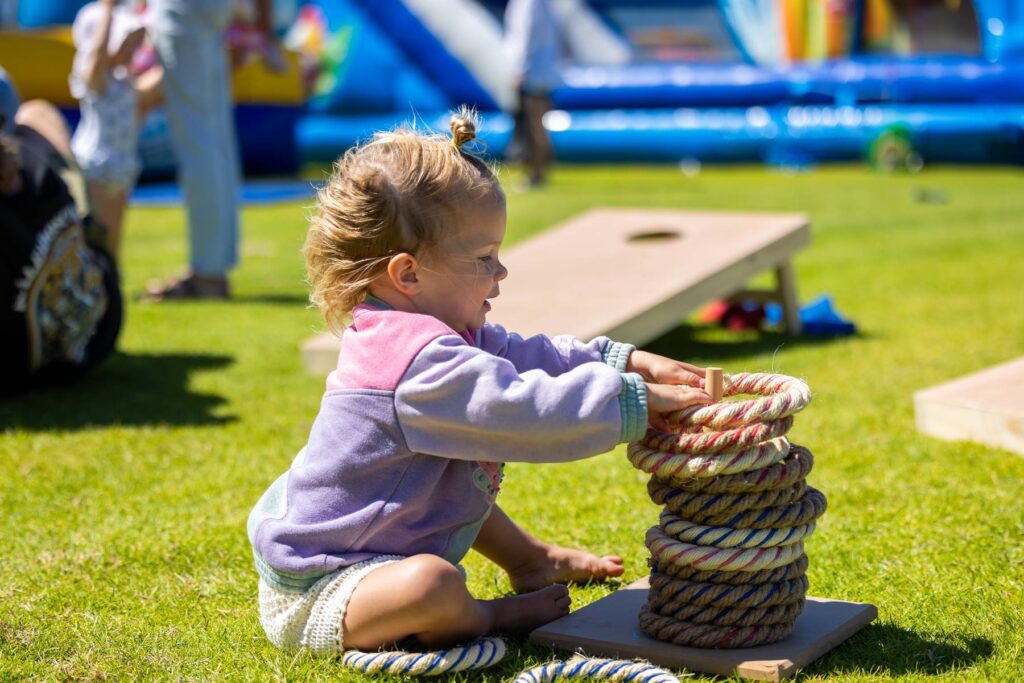 Young child playing quoits in the Kids Zone during the TCF